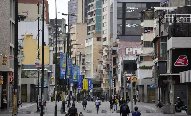 People walk along Sabana Grande Boulevard in Caracas, Venezuela, Monday, July 29, 2024, the day after the presidential election. (AP Photo/Matias Delacroix)