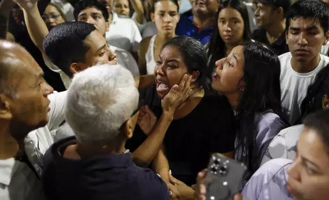 Supporters of opposition candidate Edmundo Gonzalez gather outside the Andres Bello School voting center asking to know results after polls closed for presidential elections in Caracas, Venezuela, Sunday, July 28, 2024. (AP Photo/Cristian Hernandez)