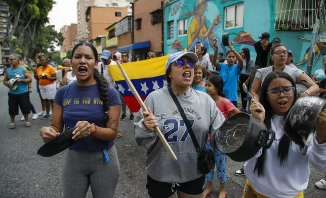 Residents bang pots and pans to protest the day after the presidential election in Caracas, Venezuela, Monday, July 29, 2024. (AP Photo/Cristian Hernandez)