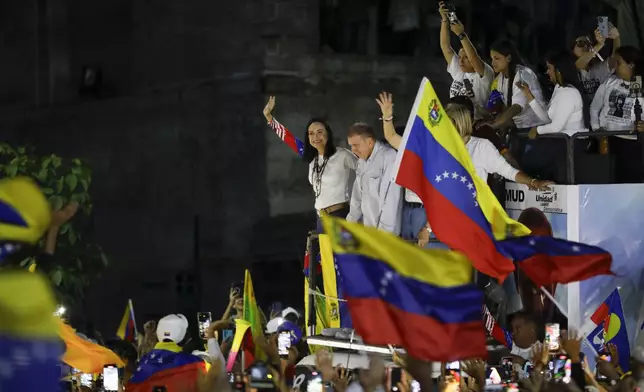 Opposition leader Maria Corina Machado and presidential candidate Edmundo Gonzalez wave to supporters during their closing campaign rally in Caracas, Venezuela, Thursday, July 25, 2024. The presidential election is set for July 28. (AP Photo/Cristian Hernandez)