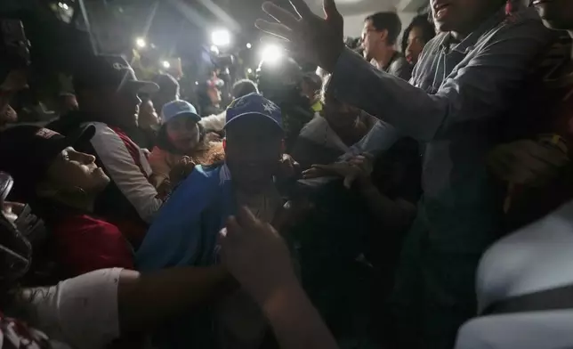 Government supporters, left, face off with opposition backers outside a voting center during the presidential election in Caracas, Venezuela, Sunday, July 28, 2024. (AP Photo/Matias Delacroix)