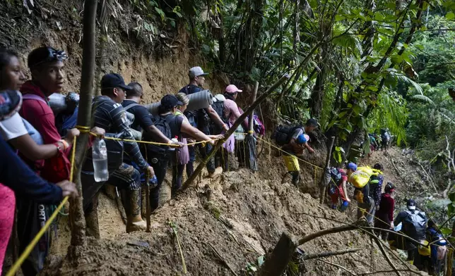 FILE - Migrants, mostly Venezuelans, walk across the Darien Gap from Colombia into Panama, hoping to reach the U.S., Oct. 15, 2022. Refugee agency UNHCR estimates more than 7.7 million Venezuelans have left since 2014, the largest exodus in Latin America’s recent history, with most settling in the Americas, from neighboring Colombia and Brazil to Argentina and Canada. (AP Photo/Fernando Vergara, File)