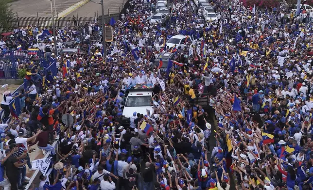 Presidential candidate Edmundo Gonzalez, center, and opposition leader Maria Corina Machado, center right, greet supporters during a campaign rally in Maracaibo, Venezuela, Tuesday, July 23, 2024. The presidential election is set for July 28. (AP Photo/Matias Delacroix)