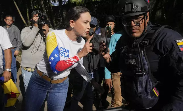 Venezuelan opposition leader Maria Corina Machado argues with police officers delaying her passage to the opening presidential campaign rally in Caracas, Venezuela, Thursday, July 4, 2024. Venezuela is set to hold its presidential election on July 28. (AP Photo/Ariana Cubillos)