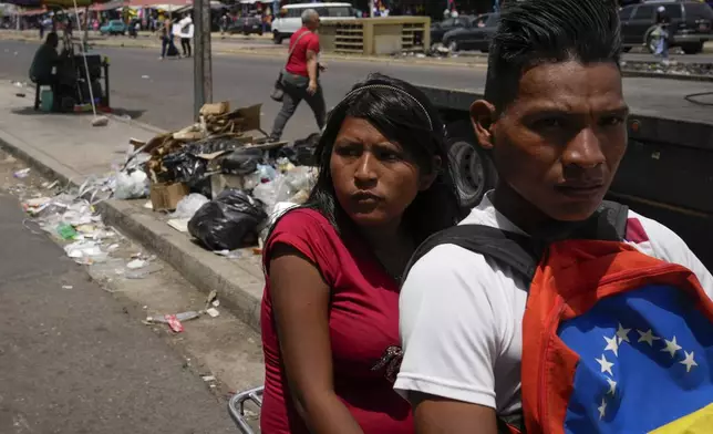 A couple passes by on a motorbike near a flea market in Maracaibo, Venezuela, Monday, July 22, 2024. The country's presidential election is set for July 28. (AP Photo/Matias Delacroix)