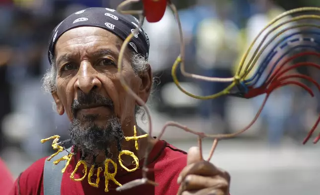 A supporter of Venezuelan President Nicolas Maduro features the president's name woven into his beard as he waits for the start of the president's closing campaign rally as he seeks reelection in Caracas, Venezuela, Thursday, July 25, 2024. The presidential election is set for July 28. (AP Photo/Cristian Hernandez)