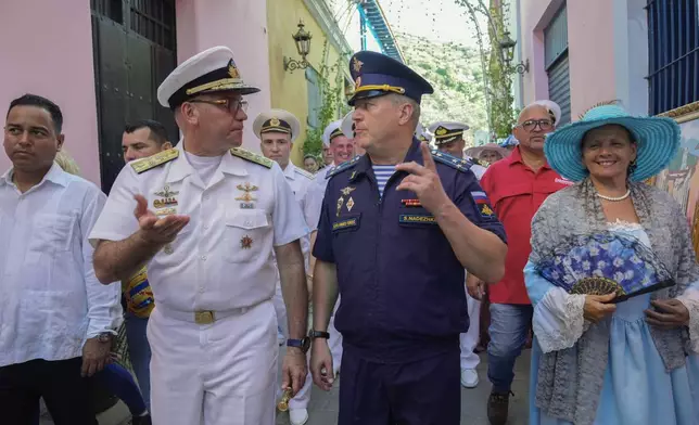 Venezuelan Vice Adm. Edward Centeno Mass, left, speaks with a member of the Russian Armed Forces during a welcoming tour by official authorities in La Guaira, Venezuela, after the Almirante Gorshkov frigate and Akademik Pashin oil tanker of the Russian Navy docked there, Tuesday, July 2, 2024. (AP Photo/Ariana Cubillos)