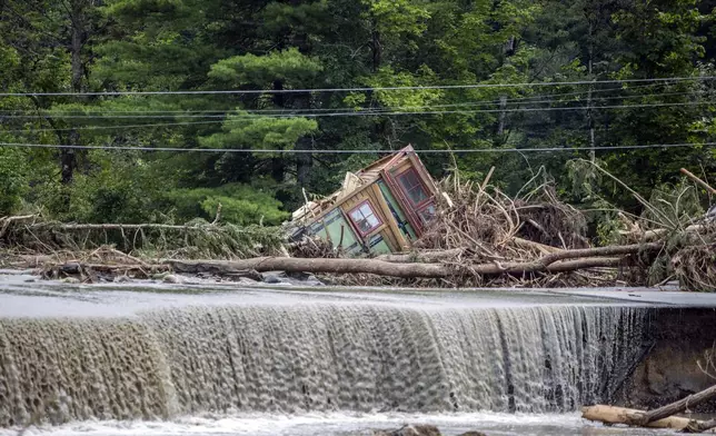 A damaged house sits amid flood debris in Lyndon, Vt., Tuesday, July 30, 2024. (AP Photo/Dmitry Belyakov)