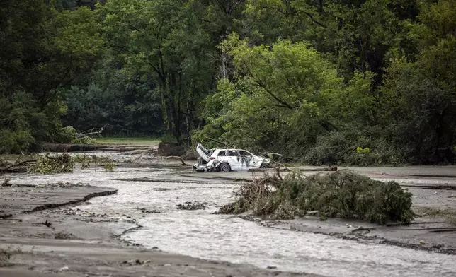 A damaged car sits amid flood debris in Lyndon, Vt., Tuesday, July 30, 2024. (AP Photo/Dmitry Belyakov)