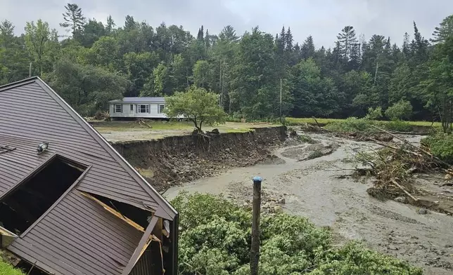 In this photo provided by the Lyndonville Fire Department, damaged homes sit alongside a river in Lyndonville, Vt., after flash floods hit the area, Tuesday, July 30, 2024. (Lyndonville Fire Chief Jeff Carrow via AP)