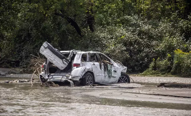 A damaged car sits amid flood debris in Lyndon, Vt., Tuesday, July 30, 2024. (AP Photo/Dmitry Belyakov)