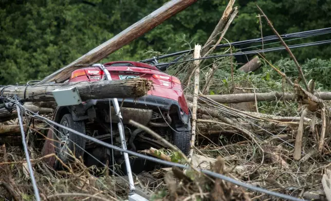 A damaged car sits amid flood debris in Lyndon, Vt., Tuesday, July 30, 2024. (AP Photo/Dmitry Belyakov)