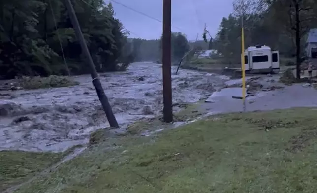 In this image taken from video provided by Deryck Colburn, floods triggered by heavy rain wash out a road in Lyndonville, Vt., during an extreme weather event that led to about two dozen rescues in northern Vermont Tuesday, July 30, 2024, nearly three weeks after many farmers and residents in the state were hit by flooding from the remnants of Hurricane Beryl. (Deryck Colburn via AP)