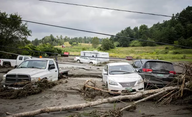 Damaged cars sit amid flood debris in Lyndon, Vt., Tuesday, July 30, 2024. (AP Photo/Dmitry Belyakov)