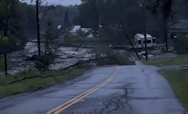 In this image taken from video provided by Deryck Colburn, floods triggered by heavy rain wash out a road in Lyndonville, Vt., during an extreme weather event that led to about two dozen rescues in northern Vermont Tuesday, July 30, 2024, nearly three weeks after many farmers and residents in the state were hit by flooding from the remnants of Hurricane Beryl. (Deryck Colburn via AP)