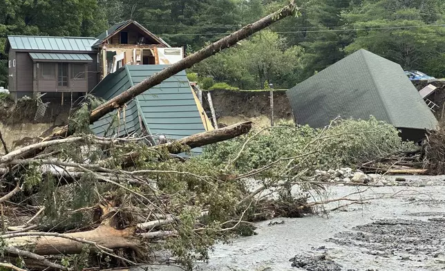 Trees and debris sit next to a damaged home after flooding in Lyndonville, Vt., Tuesday, July 30, 2024. (AP Photo/Nick Perry)