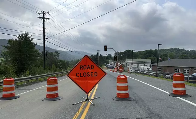 A road is closed in St. Johnsbury, Vermont after flooding in the region, Tuesday, July 30, 2024. Heavy rain has washed out some roads and led to about two dozen rescues in northern Vermont, nearly three weeks after many farmers and residents in the state were hit by flooding from the remnants of Hurricane Beryl. The National Weather Service in Burlington says some areas got 6 to 8 inches of rain starting late Monday and saw flash flooding. (AP Photo/Lisa Rathke)