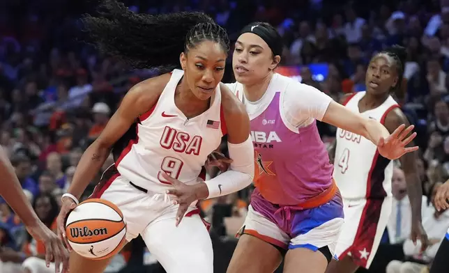 A'ja Wilson (9), of Team USA, drives past Dearica Hamby, front right, of Team WNBA, during the first half of a WNBA All-Star basketball game Saturday, July 20, 2024, in Phoenix. (AP Photo/Ross D. Franklin)