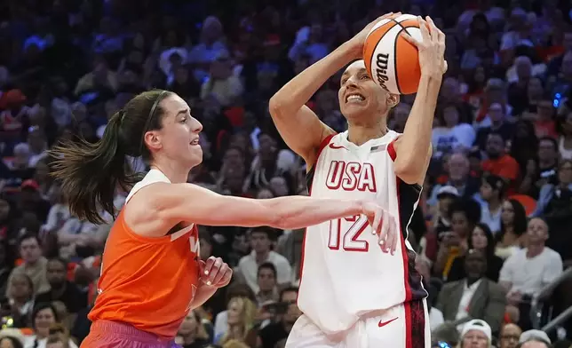 Diana Taurasi (12), of Team USA, is fouled by Caitlin Clark, left, of Team WNBA, during the first half of a WNBA All-Star basketball game Saturday, July 20, 2024, in Phoenix. (AP Photo/Ross D. Franklin)