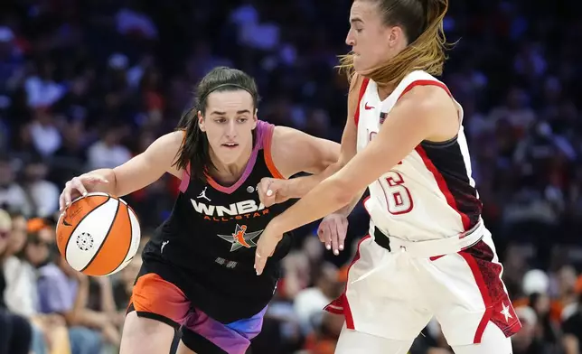 Caitlin Clark, left, of Team WNBA, dribbles against Sabrina Ionescu (6), of Team USA, during the second half of a WNBA All-Star basketball game Saturday, July 20, 2024, in Phoenix. (AP Photo/Ross D. Franklin)