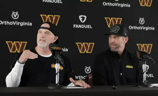 Washington Commanders head coach Dan Quinn, left, speaks as general manager Adam Peters, right, looks on during an NFL football press conference in Ashburn, Va., Tuesday, July 23, 2024. (AP Photo/Luis M. Alvarez)