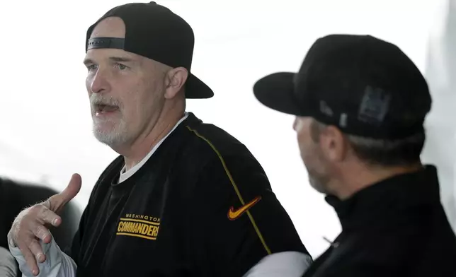 Washington Commanders head coach Dan Quinn, left, speaks as general manager Adam Peters, right, looks on during an NFL football press conference in Ashburn, Va., Tuesday, July 23, 2024. (AP Photo/Luis M. Alvarez)