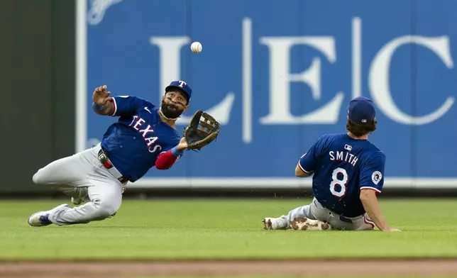 Texas Rangers right fielder Derek Hill, left, with backup from third baseman Josh Smith (8), catches a fly ball hit by Baltimore Orioles' Cedric Mullins during the second inning of a baseball game Thursday, June 27, 2024, in Baltimore. (AP Photo/Stephanie Scarbrough)