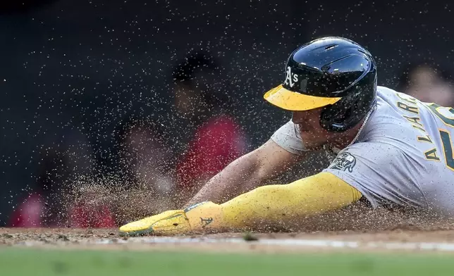 Oakland Athletics' Armando Alvarez slides home to score during the third inning of a baseball game against the Los Angeles Angels, Tuesday, June 25, 2024, in Anaheim, Calif. (AP Photo/Ryan Sun)