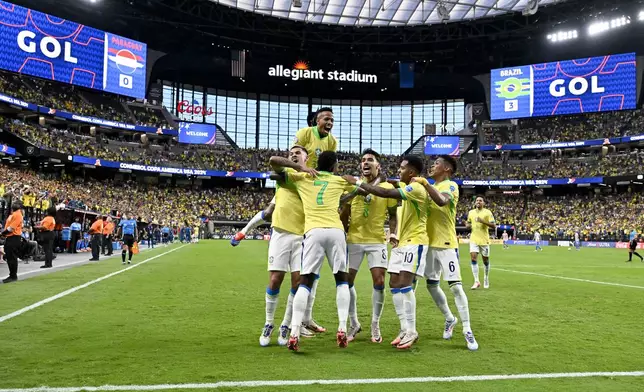 Brazil's Vinicius Junior (7) celebrates with teammates after scoring his side's third goal against Paraguay during a Copa America Group D soccer match in Las Vegas, Friday, June 28, 2024. (AP Photo/David Becker)