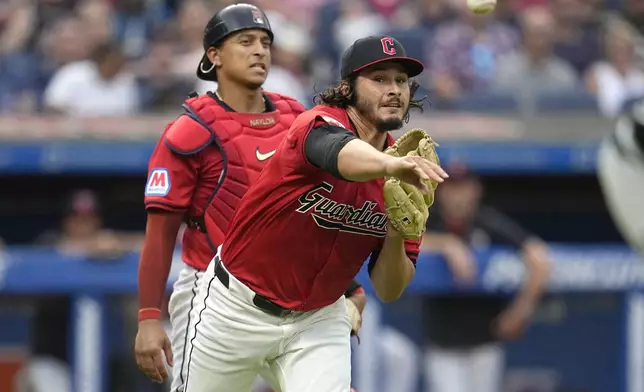 Cleveland Guardians pitcher Eli Morgan, right, throws out Chicago White Sox's Martin Maldonado at first base in the sixth inning of a baseball game Wednesday, July 3, 2024, in Cleveland. (AP Photo/Sue Ogrocki)