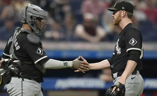 Chicago White Sox catcher Martin Maldonado, left, shakes hands with relief pitcher Steven Wilson, right, after the White Sox defeated the Guardians in a baseball game Wednesday, July 3, 2024, in Cleveland. (AP Photo/Sue Ogrocki)