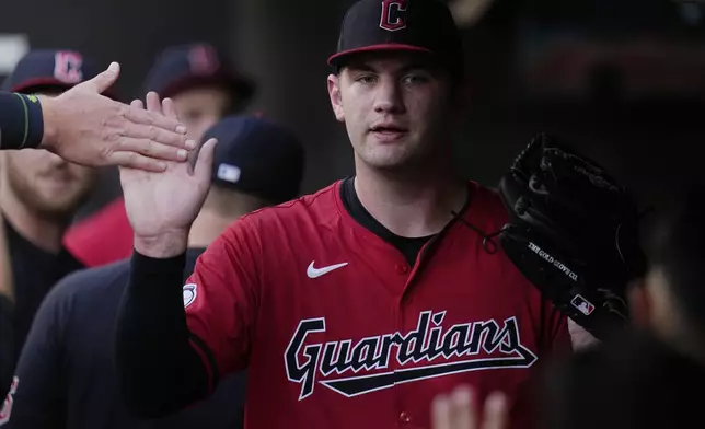 Cleveland Guardians starting pitcher Gavin Williams is greeted in the dugout after the second inning of a baseball game against the Chicago White Sox, Wednesday, July 3, 2024, in Cleveland. (AP Photo/Sue Ogrocki)