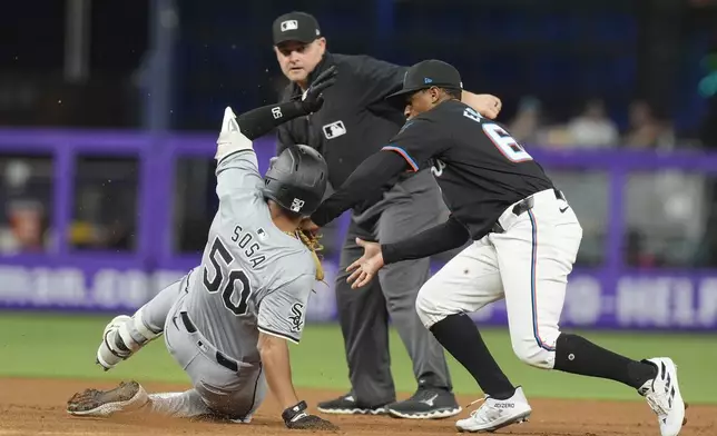 Miami Marlins shortstop Xavier Edwards (63) tags out Chicago White Sox's Lenyn Sosa (50) as Sosa tried to reach second base during the second inning of a baseball game, Friday, July 5, 2024, in Miami. (AP Photo/Marta Lavandier)