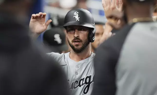 Chicago White Sox's Paul DeJong celebrates with teammates after scoring on a hit by Nicky Lopez during the second inning of a baseball game against the Miami Marlins, Friday, July 5, 2024, in Miami. (AP Photo/Marta Lavandier)