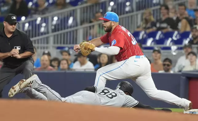 Chicago White Sox's Luis Robert Jr. (88) is caught off base as Miami Marlins first baseman Jake Burger, top right, catches the ball for an out during the first inning of a baseball game, Saturday, July 6, 2024, in Miami. (AP Photo/Marta Lavandier)