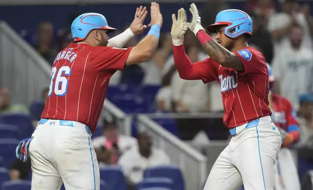 Miami Marlins' Dane Myers, right, celebrates after his two-run home run with Jake Burger (36) during the fourth inning of a baseball game against the Chicago White Sox, Saturday, July 6, 2024, in Miami. (AP Photo/Marta Lavandier)