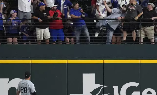 Chicago White Sox outfielder Tommy Pham (28) looks on as Texas Rangers' Corey Seager's home run clears the wall during the first inning of a baseball game in Arlington, Texas, Wednesday, July 24, 2024. (AP Photo/LM Otero)