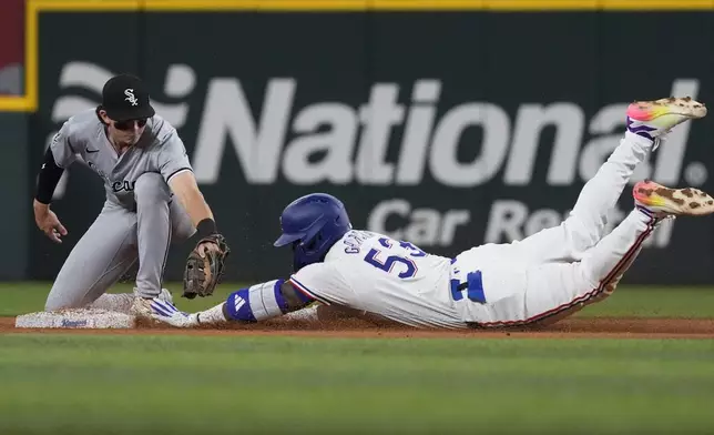 Texas Rangers' Adolis García (53) safely reaches second base on a double against Chicago White Sox shortstop Brooks Baldwin during the firth inning of a baseball game in Arlington, Texas, Wednesday, July 24, 2024. Rangers' Corey Seager scored on the play. (AP Photo/LM Otero)