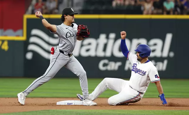 Chicago White Sox second baseman Nicky Lopez (8) forces out Texas Rangers' Marcus Semien (2) as he throws to first for the double play the first inning of a baseball game Thursday, July 25, 2024, in Arlington, Texas. (AP Photo/Richard W. Rodriguez)