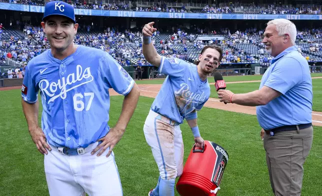 Kansas City Royals' Bobby Witt Jr., center, leads the crowd in chanting the name of starter Seth Lugo 67) after Lugo pitched a complete baseball game in a win over the Chicago White Sox, Sunday, July 21, 2024, in Kansas City, Mo. (AP Photo/Reed Hoffmann)