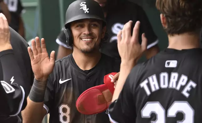 Chicago White Sox's Nicky Lopez (8) is congratulated after scoring on a single by teammate Tommy Pham during the sixth inning of a baseball game against the Kansas City Royals, Sunday, July 21, 2024, in Kansas City, Mo. (AP Photo/Reed Hoffmann)