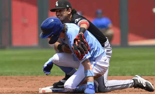 Chicago White Sox shortstop Nicky Lopez, top, gives former teammate Kansas City Royals' Bobby Witt Jr. a hug after forcing him out at second base during the first inning of a baseball game, Sunday, July 21, 2024, in Kansas City, Mo. (AP Photo/Reed Hoffmann)