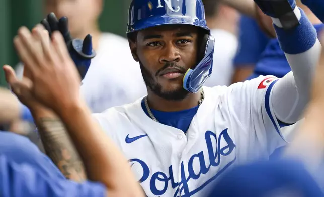 Kansas City Royals' Maikel Garcia is congratulated after scoring on a Bobby Witt Jr. double against the Chicago White Sox during the second inning of a baseball game, Saturday, July 20, 2024, in Kansas City, Mo. (AP Photo/Reed Hoffmann)