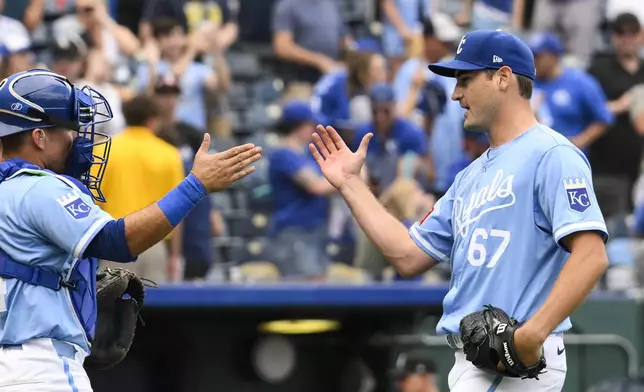 Kansas City Royals starting pitcher Seth Lugo (67) is congratulated by Royals catcher Freddy Fermin, left, after pitching a complete baseball game to defeat the Chicago White Sox, Sunday, July 21, 2024, in Kansas City, Mo. (AP Photo/Reed Hoffmann)