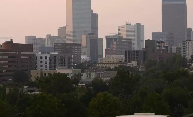 The skyline is obscured by wildfire smoke from blazes in the American West and provinces of western Canada late Wednesday, July 24, 2024, in Denver. (AP Photo/David Zalubowski)