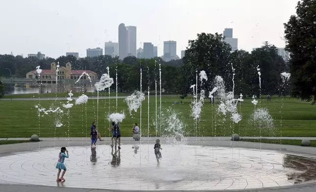 Haze hangs in the air as children play in a fountain in Denver , Wednesday, July 24, 2024. Fires burning in California, Oregon, Arizona, Washington and other western states, as well as Canada, have filled the skies in regions of the western U.S. with smoke and haze, forcing some affected areas to declare air quality alerts or advisories. (AP Photo/Thomas Peipert)