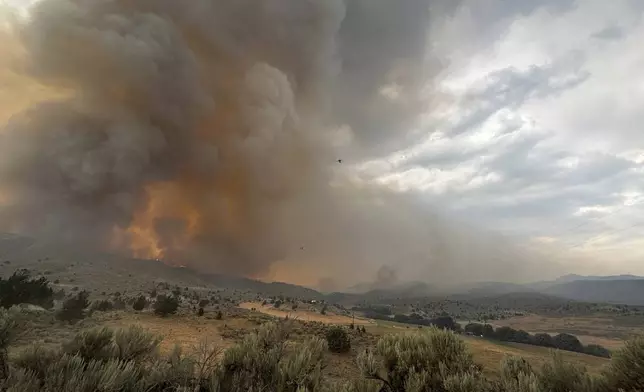 In this image provided by the U.S. Department of Agriculture Forest Service, smoke rises from a wildfire on Monday, July 22, 2024, near Durkee, Ore. In eastern Oregon, evacuation orders were lifted Thursday for the city of Huntington, population 500, after a severe thunderstorm late Wednesday brought some rain and cooler temperatures to the nearly 630 square miles (1,630 square kilometers) burned by the Durkee Fire, the nation's biggest, and another nearby blaze. (Brett Brown/USDA Forest Service via AP)