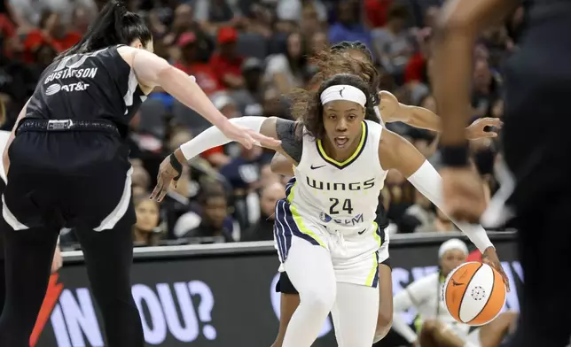 Dallas Wings guard Arike Ogunbowale (24) drives against Las Vegas Aces center Megan Gustafson (17) during the first half of an WNBA basketball game, Sunday, July 7, 2024, in Las Vegas. (Steve Marcus/Las Vegas Sun via AP)