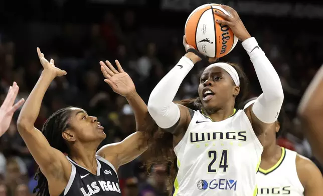 Dallas Wings guard Arike Ogunbowale (24) shoots over Las Vegas Aces guard Tiffany Hayes during the first half of an WNBA basketball game, Sunday, July 7, 2024, in Las Vegas. (Steve Marcus/Las Vegas Sun via AP)