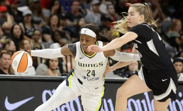 Dallas Wings guard Arike Ogunbowale (24) drives against Las Vegas Aces guard Kate Martin, right, during the first half of a WNBA basketball game Sunday, July 7, 2024, in Las Vegas. (Steve Marcus/Las Vegas Sun via AP)